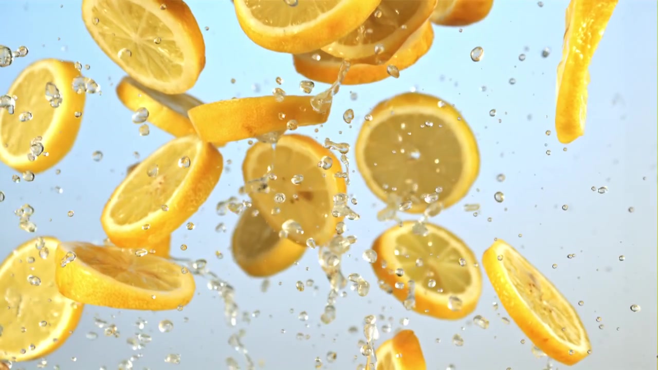 Fresh Lemon Slices Falling with Water Splashes in Slow Motion