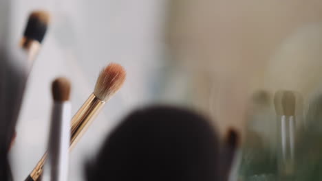 different cosmetic brushes on workplace of makeup artist