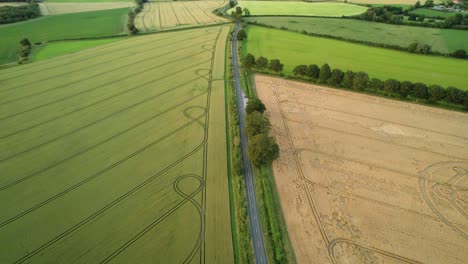 green wiltshire farmland countryside crop circle molecular pattern aerial view rural scene pull back