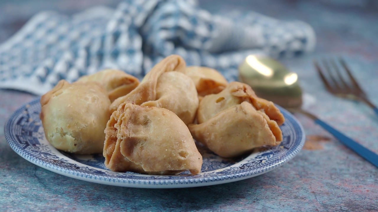 Piatto di samosa fritti croccanti su un tavolo rustico