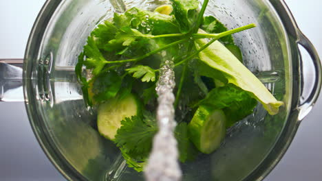 liquid pouring vegetables blender super slow motion closeup. top view mixer bowl