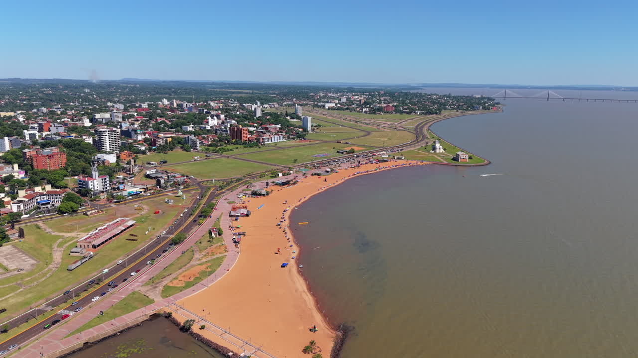 Downward aerial shot of San José Beach, Encarnación, Paraguay, on the banks of the Paraná River, on a bright sunny day.