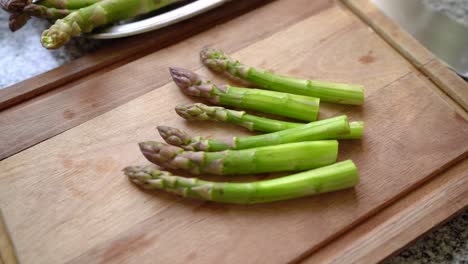 vegetal similar a una lanza de espárragos en una tabla de cortar de madera.