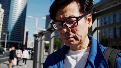 man at a bus stop in a city