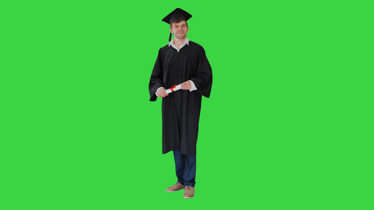 Studente maschio felice in toga da laureato che posa e saluta con il suo diploma su Green Screen, Chroma Key