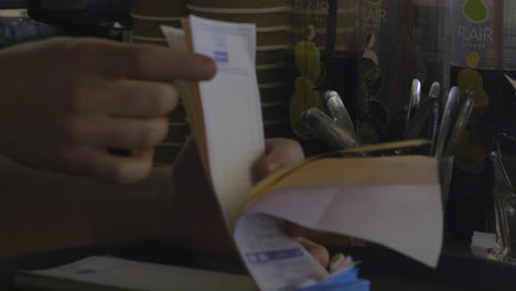 man going through receipts in a bar