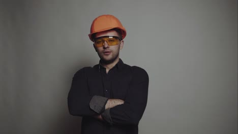 portrait of young engineer with helmet. young construction worker in hard hat on gray background