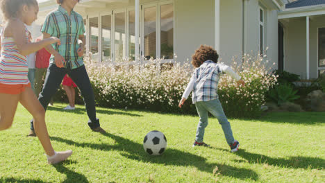 video of diverse family in playing football match outside