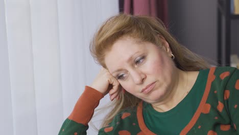 unhappy mature woman alone at home thoughtful and worried.