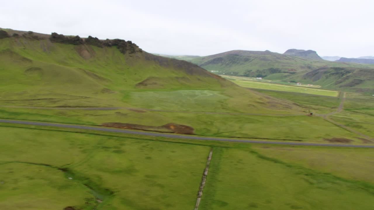 Vast Icelandic green landscape with mountains and open sky, calm mood