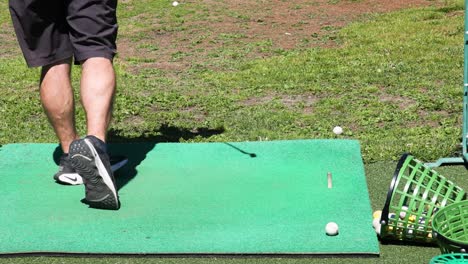 hombre practicando golfes en una alfombra verde