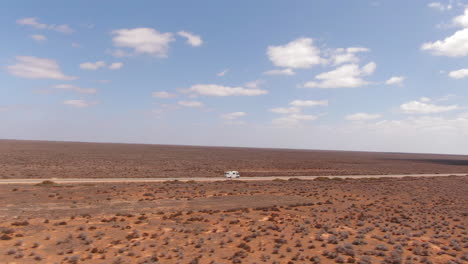 Campervan-driving-on-an-empty-long-straight-road-in-a-barren-environment