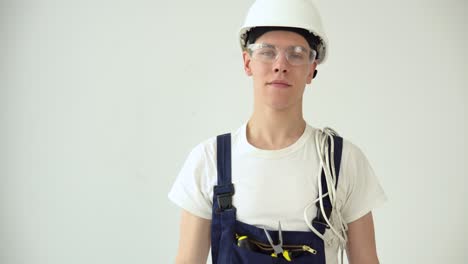 the electrician holds the sockets in his hand and looks straight ahead