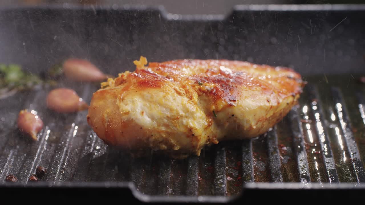 Cooking raw chicken meat in spices with garlic and greens on grill close-up. Fry chicken slice on frying.pan Grilled chicken, duck, turkey kebab with vegetables.