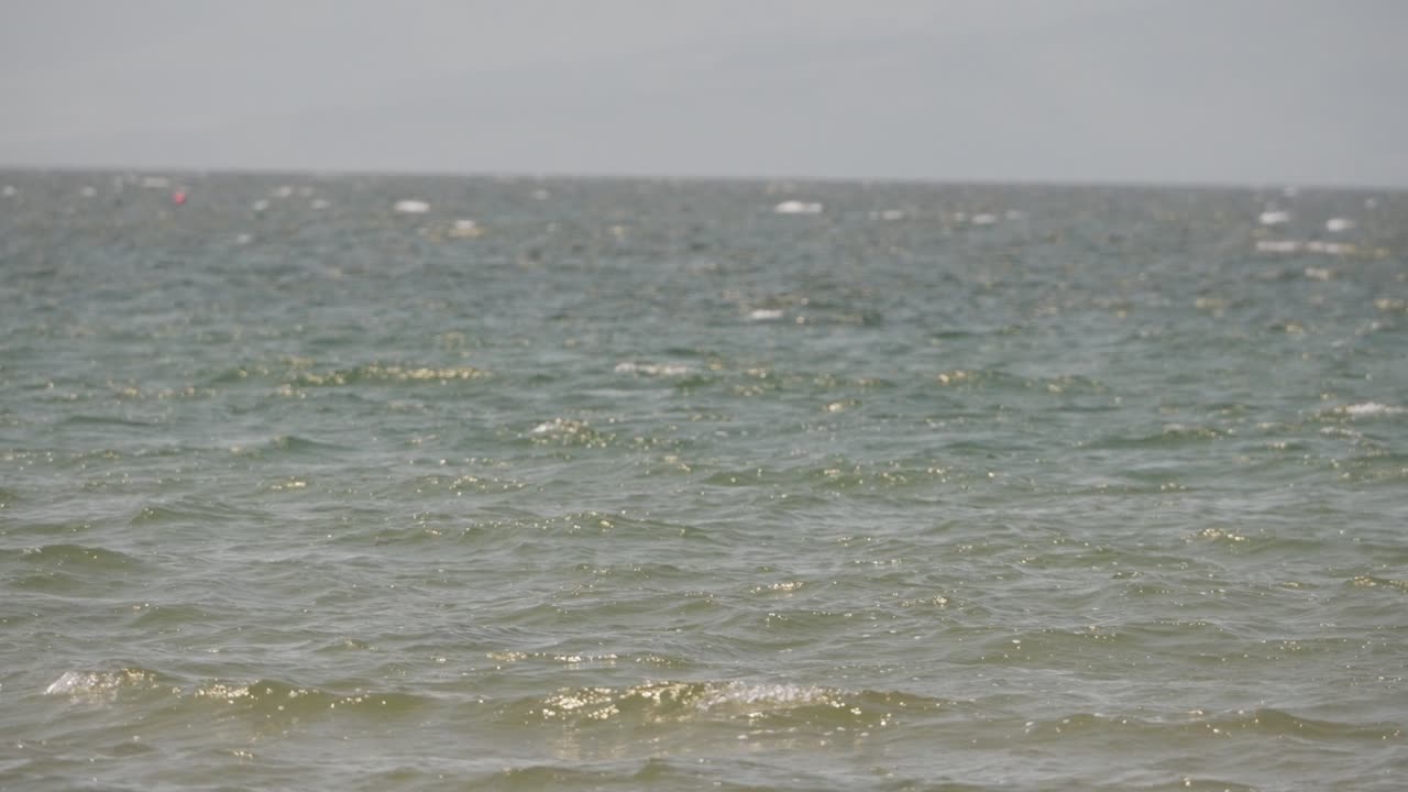 Slow motion close-up of ocean waves flowing calmly in rhythmic motion. Captures peaceful water textures and sea energy, ideal for nature backgrounds, meditative projects, or tranquil scenes
