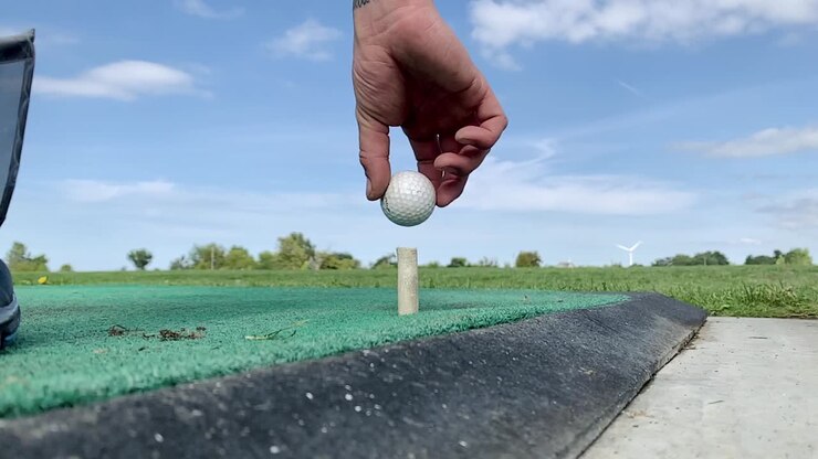Slow Motion golfer placing the ball on a tee before hitting initial shot