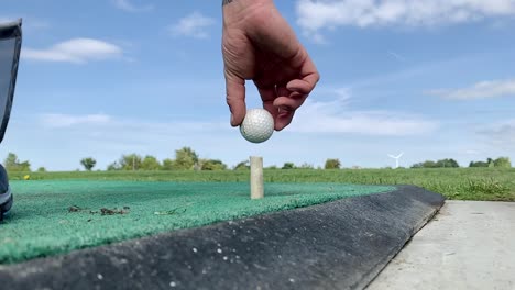 Slow-Motion-Golfspieler,-Der-Den-Ball-Auf-Ein-T-Stück-Legt,-Bevor-Er-Den-Ersten-Schlag-Trifft