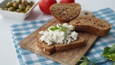 cottage cheese on whole wheat bread with olives and tomatoes