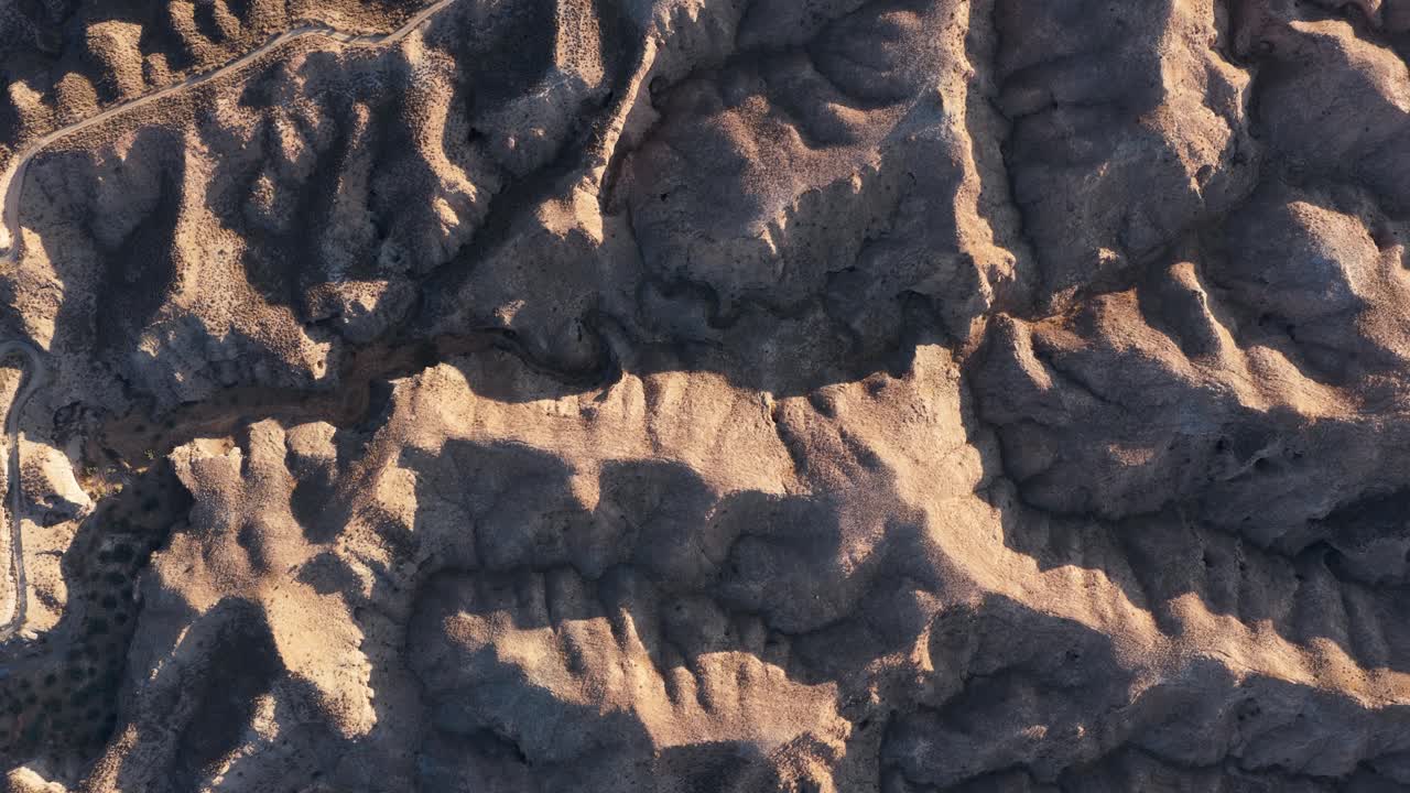 Aerial Top Down View of Rugged Desert Landscape with Shadows