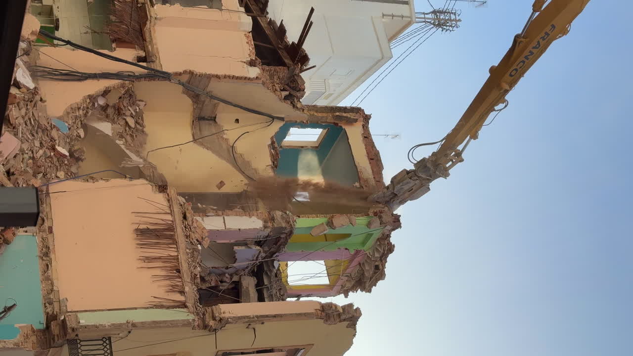 demolición de edificios con maquinaria de brazo hidráulico con pinzas