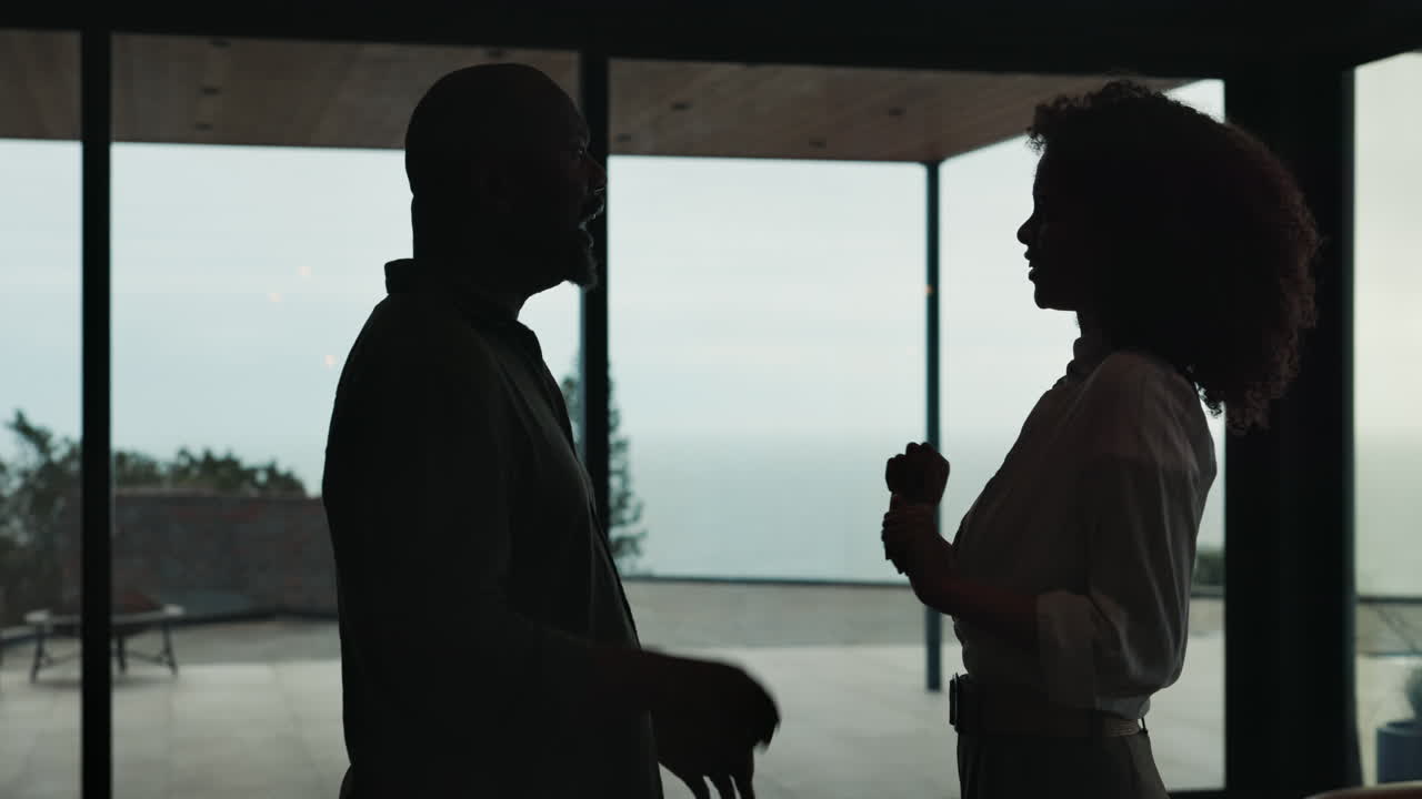 Silhouette of a man and woman in discussion