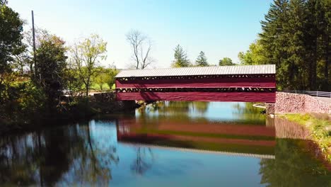 aerial over a pretty historic red covered bridge near gettysburg pennsylvania