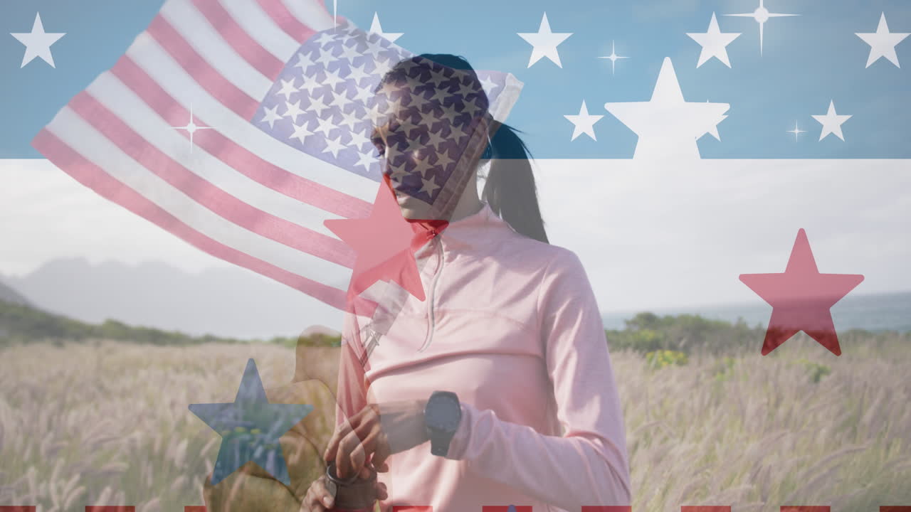 animación de la bandera estadounidense sobre una mujer biracial bebiendo agua en las montañas