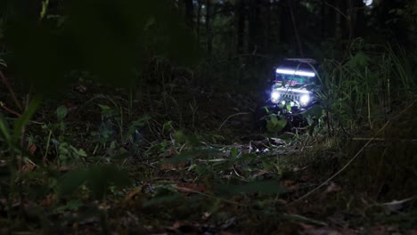 rc scale jeep driving through the forest at night