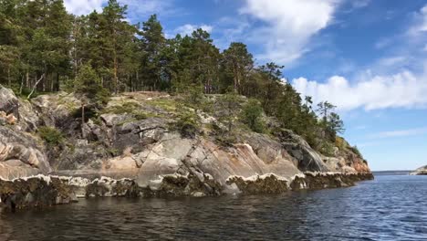 Rocky-shores-in-Karelia,-Russia-with-crystal-clear-blue-water-and-green-surroundings