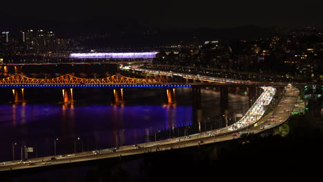 Seoul-night-view-from-Eungbong-mountain-captures-the-vibrant-cityscape-with-passing-traffic,-Dongho-Daegyo,-and-Banpo-Bridge's-light-show