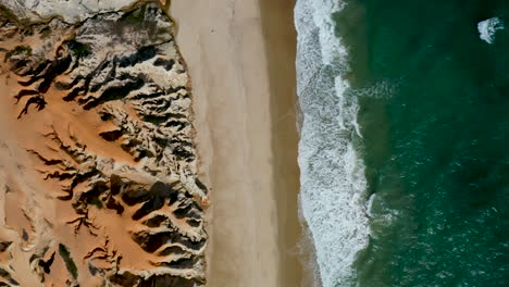 Aerial-view-of-the-sea,-waves-and-the-cliffs-of-Morro-Branco,-Ceara,-Brazil