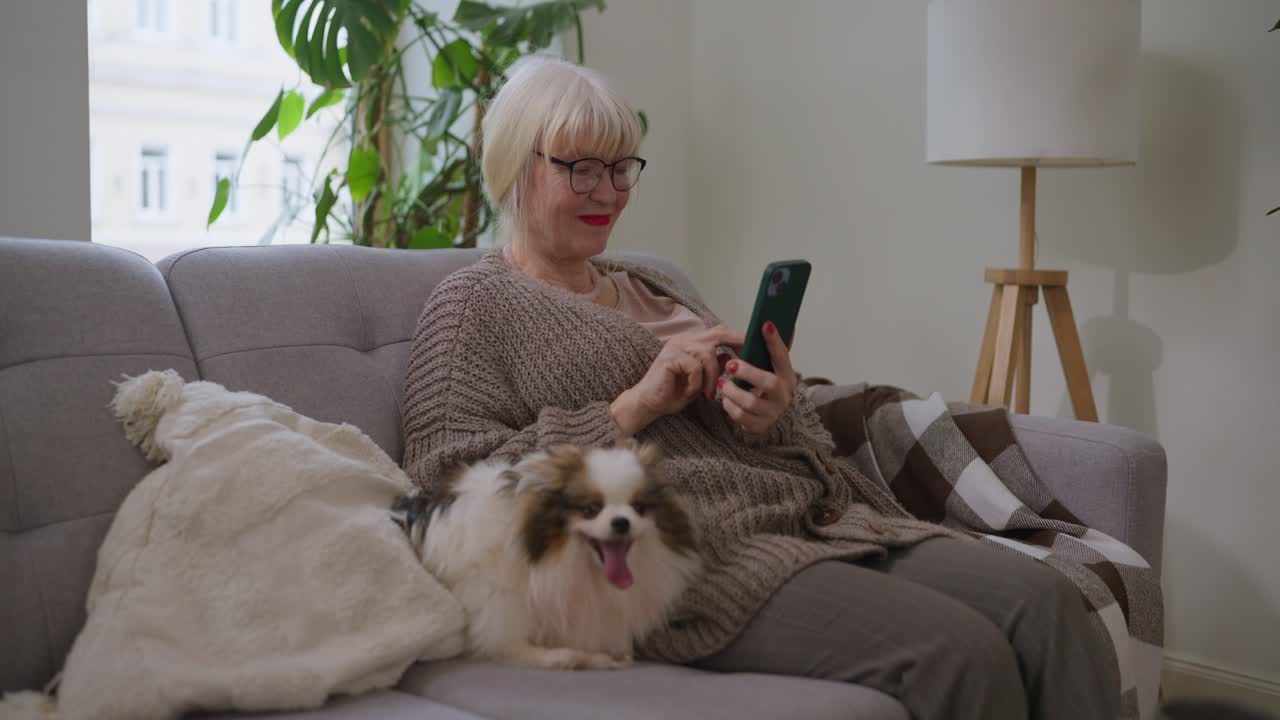Senior Woman Using Smartphone with Dog