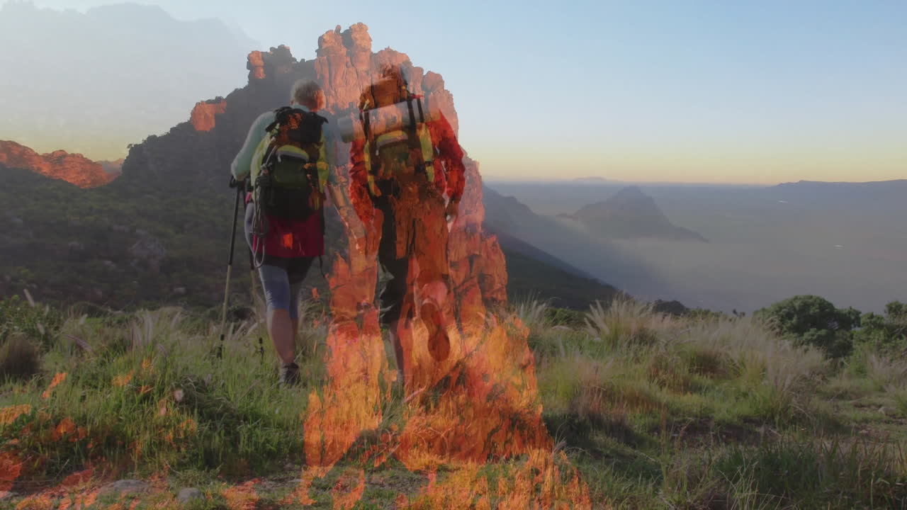 Couple hiking mountain ridge using trekking poles and backpacks showing health journey