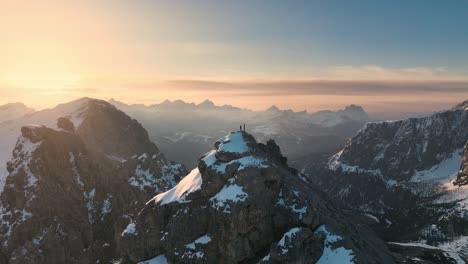 montañero parado en un pico en los dolomitas al amanecer