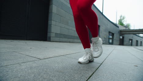 Woman-legs-running-on-street-in-slow-motion.-Close-up-female-runner-legs-jogging