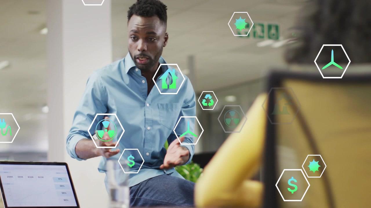 On opening laptop man pointing, hex icons energy, reuse, funds popping while explaining to coworker