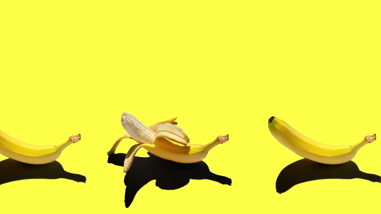 밝은 배경에 고립 된 전체 및 벗겨진 노란 바나나와 함께 원활한 루핑 애니메이션. 정오에 태양에서 단단한 그림자, 공간 복사