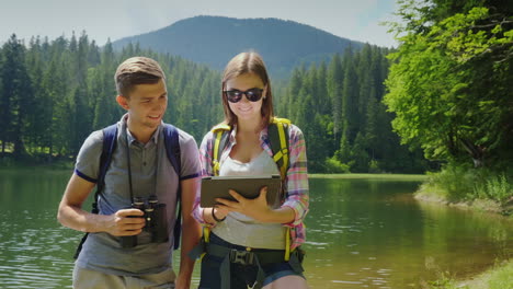 man and woman travelers together they orient themselves on the map the man looks through binoculars