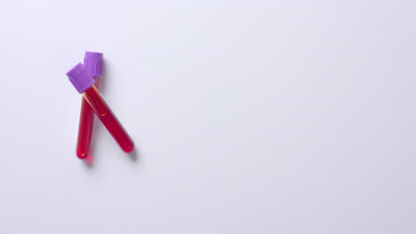 close up of blood samples on white background with copy space, slow motion