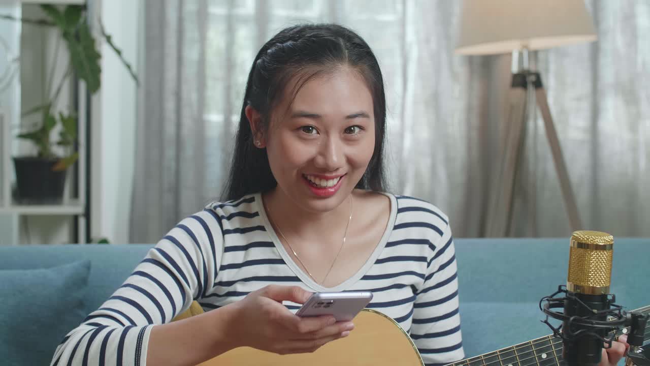 Donna che canta e suona la chitarra a casa