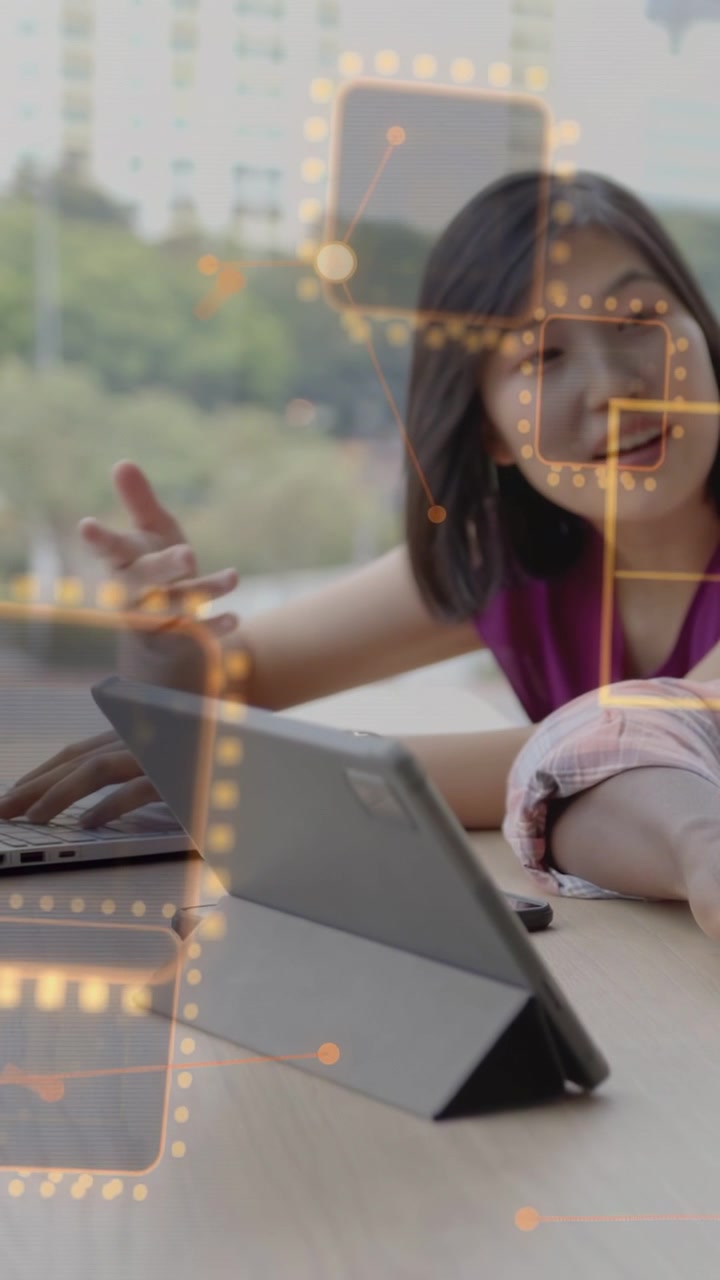 Vertical video: Woman tapping tablet while peer typing, overlaying squares on devices for business