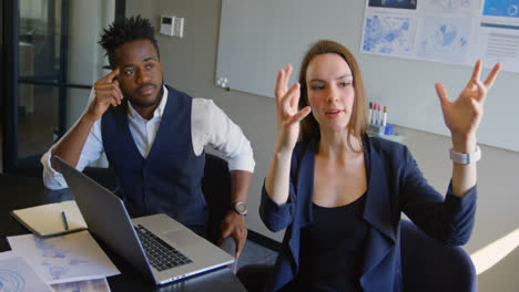 side view of young mixed-race business team planning and sitting with laptop in a modern office 4k