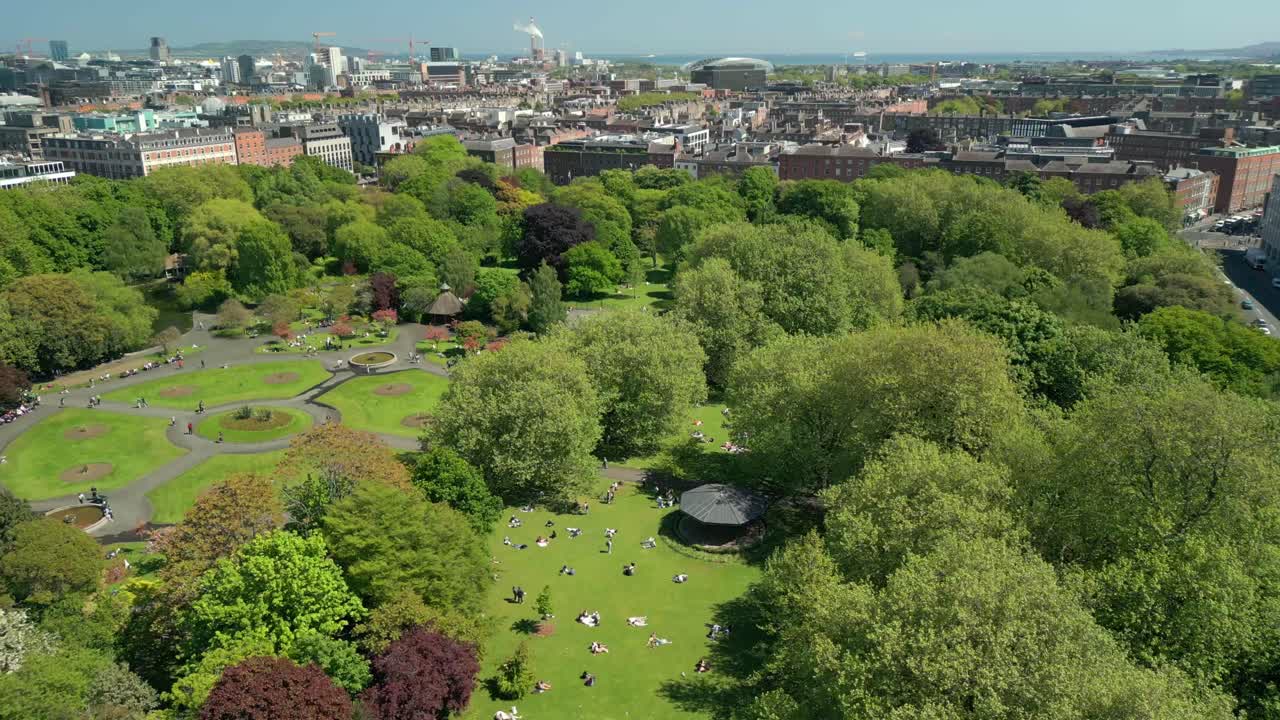 Wide, advancing aerial video of St Stephen's Green in Dublin City Centre, County Leinster, Ireland, on a bright and sunny day. Produced in 4K, 60FPS and with Rec709 color.