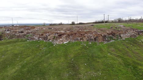 trash on the green field - aerial pullback
