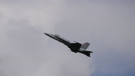 a jet zooms across a clear blue sky during an airshow, leaving a smoke trail behind as it performs stunts, fa-18 at airpower airshow