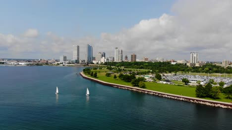 Slow-aerial-pan-of-sailboats-in-bay-with-city-skyline-in-the-background