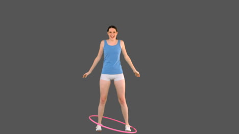joven modelo en ropa deportiva jugando con hula hoop