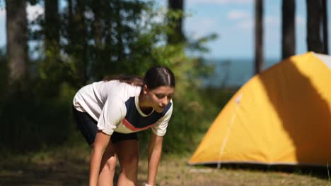 young woman camping and doing yoga