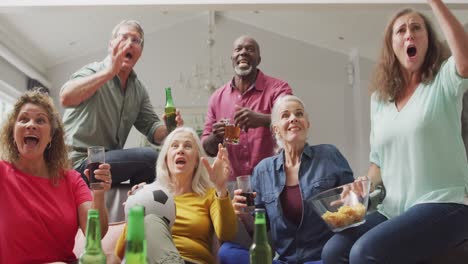 animation of happy diverse senior friends cheering while watching american football match in tv