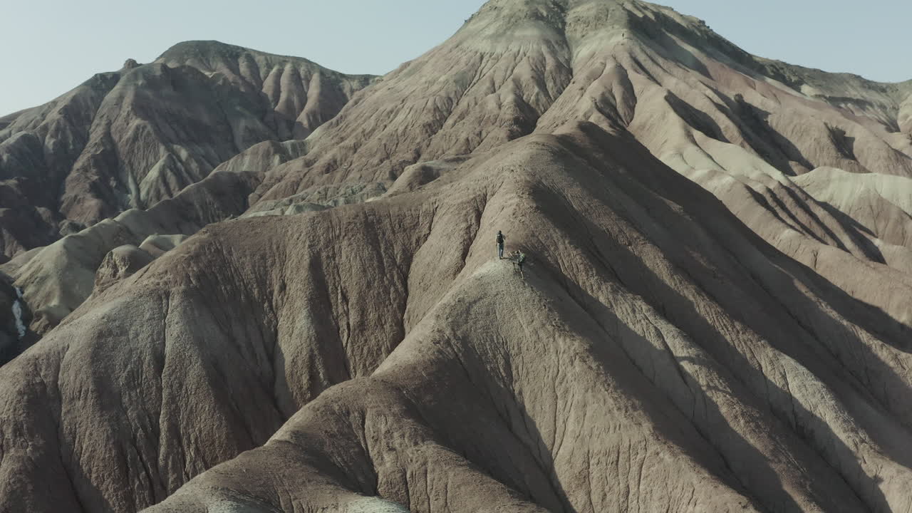 Hiker trekking across rugged desert mountains in Iran